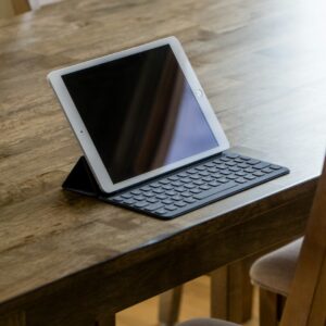 Tablet with a keyboard case sits on a wooden table.